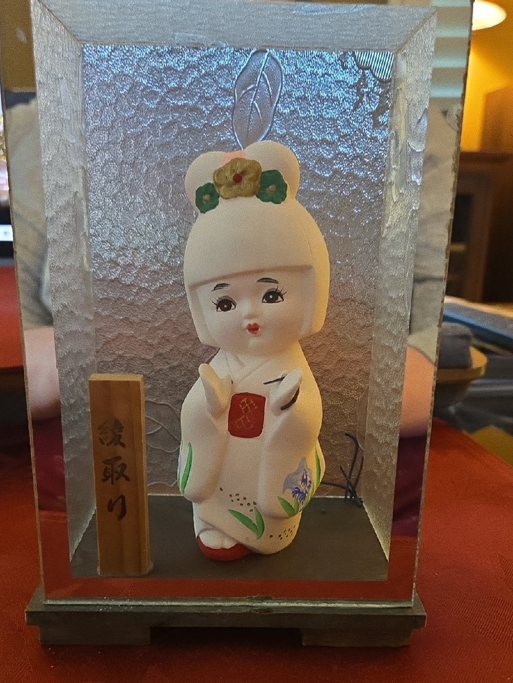 Japanese Kokeshi Doll Figurine with Floral Accents In A Glass Display Case.